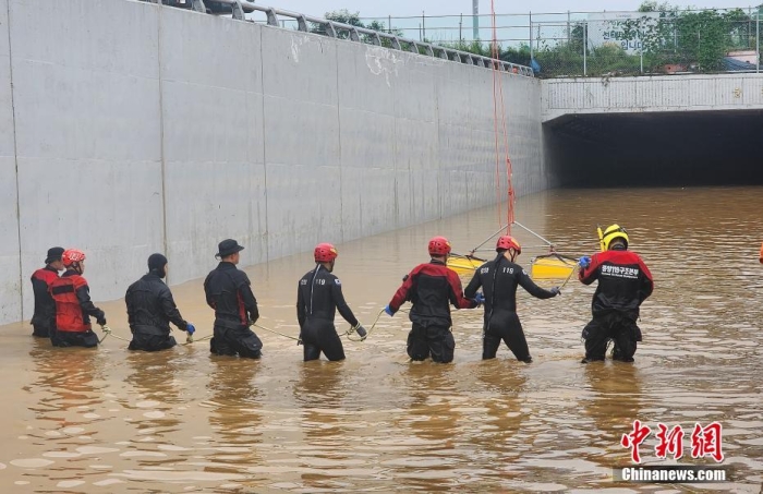 韓國救援人員沿著一條被洪水淹沒的道路搜尋失蹤人員，這條道路通往被洪水淹沒的地下隧道。視覺中國