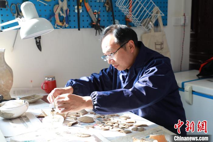 圖為工作人員在修復(fù)文物?！〈闻?攝