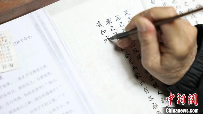 “微書寫卷”非遺傳承人謝小品正在書寫微書?！【抟翱h融媒體中心供圖