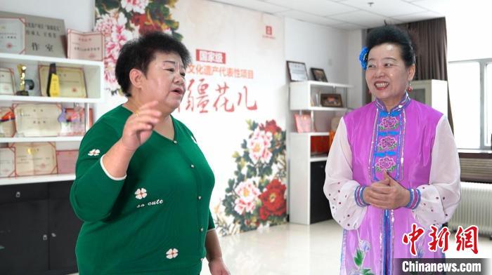 王秀芳一邊唱一邊向跟她學(xué)習(xí)“新疆花兒”的愛好者講解歌詞的含義 戎睿 攝