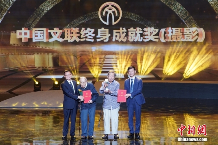 圖為中國文聯(lián)黨組成員、副主席徐永軍，中國文聯(lián)副主席、中國攝影家協(xié)會(huì)主席李舸為獲得中國文聯(lián)終身成就獎(jiǎng)(攝影)的張崇岫(左二)、蔣鐸(右二)兩位作出突出貢獻(xiàn)的攝影家頒獎(jiǎng)。<a target='_blank' href='/'>中新社</a>記者 毛建軍 攝