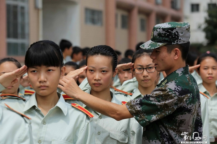 圖7：8月23日，在廣西柳州市融安縣高級中學(xué)操場，一名軍事教官在糾正一名學(xué)生敬禮動作。（譚凱興攝）副本
