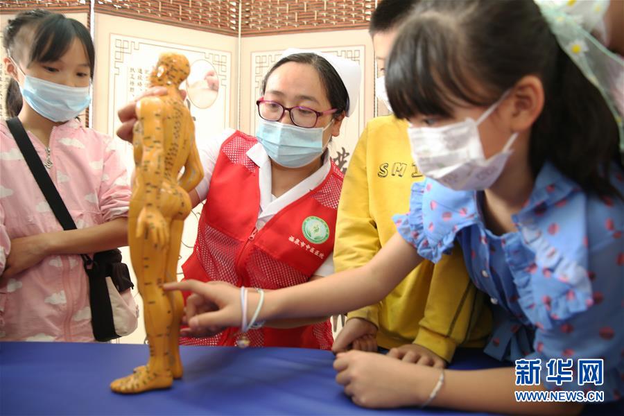 5月31日，在貴州省黔南布依族苗族自治州福泉市中醫(yī)醫(yī)院，醫(yī)務(wù)人員向小朋友介紹人體穴位知識(shí)。 新華社發(fā)（黃歡 攝）