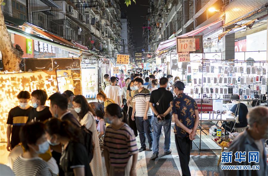 6月1日，市民在武漢保成路夜市消費休閑。 隨著復(fù)工復(fù)產(chǎn)復(fù)市持續(xù)推進，武漢街頭傳統(tǒng)的夜市再次熱鬧起來，不少市民前來消費休閑，初夏的煙火氣充滿生機。 新華社記者 熊琦 攝