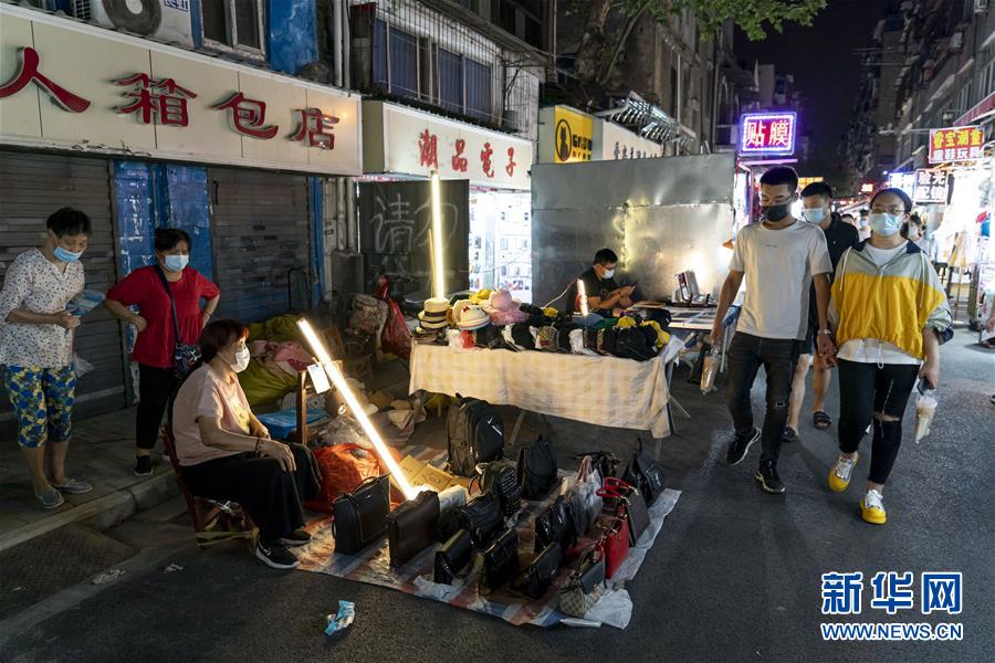 6月1日，市民在武漢保成路夜市消費休閑。 隨著復(fù)工復(fù)產(chǎn)復(fù)市持續(xù)推進，武漢街頭傳統(tǒng)的夜市再次熱鬧起來，不少市民前來消費休閑，初夏的煙火氣充滿生機。 新華社記者 熊琦 攝