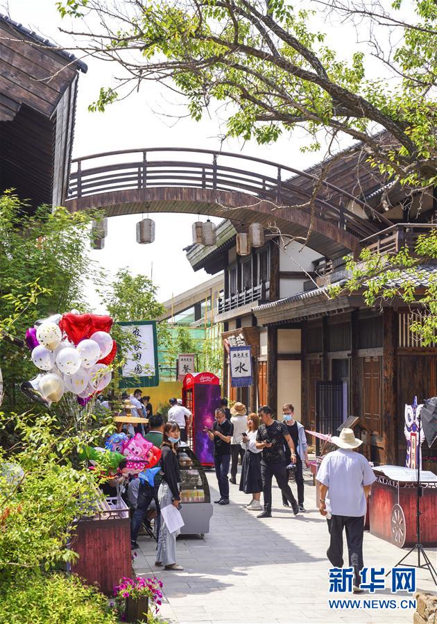 6月13日，市民在長(zhǎng)春市世茂蓮花山小鎮(zhèn)寬厚里商街參觀游覽。 當(dāng)日是“文化和自然遺產(chǎn)日”。吉林長(zhǎng)春首屆蓮花山消夏生活節(jié)在世茂蓮花山小鎮(zhèn)舉行。活動(dòng)將非遺展示與假日消暑休閑相結(jié)合，讓游人在“古色古香”的油紙傘巷中品傳統(tǒng)文化魅力，享夏日休閑愜意。 新華社記者 許暢 攝