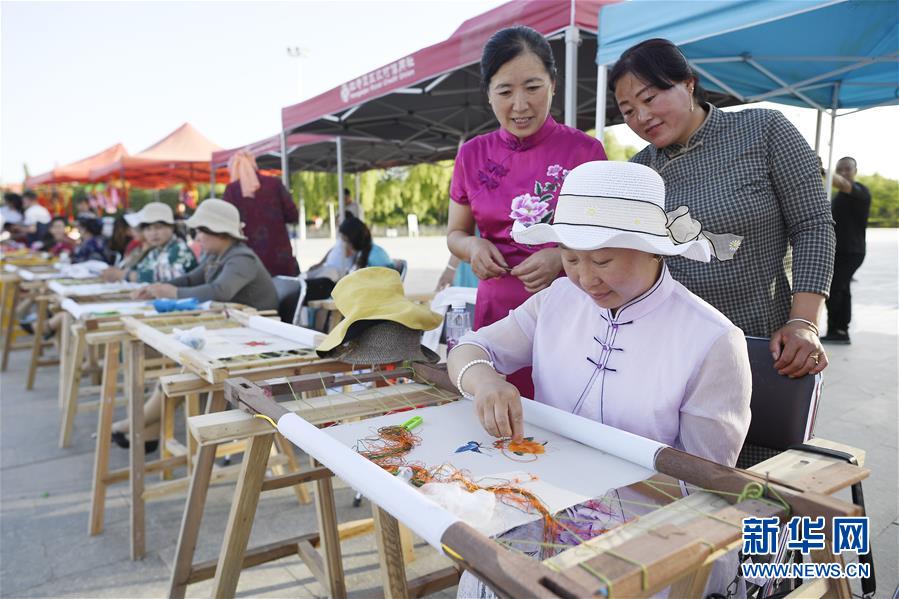 6月23日，民間刺繡藝人在現(xiàn)場(chǎng)展示刺繡技藝。 當(dāng)日，全國最大的易地生態(tài)移民扶貧集中安置區(qū)寧夏吳忠市紅寺堡區(qū)舉行迎端午活動(dòng)，邀請(qǐng)各鄉(xiāng)鎮(zhèn)的民間剪紙、刺繡藝人現(xiàn)場(chǎng)比拼傳統(tǒng)技藝，居民現(xiàn)場(chǎng)參與包粽子大賽，共迎端午節(jié)的到來。 新華社記者 王鵬 攝