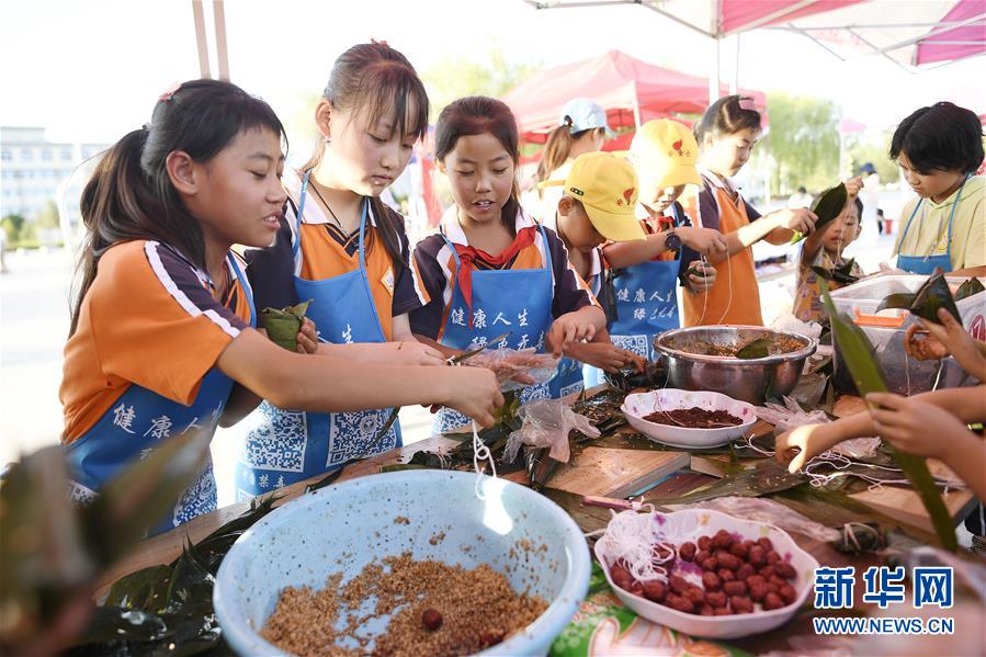 6月23日，孩子們?cè)诨顒?dòng)現(xiàn)場(chǎng)參加包粽子比賽。 當(dāng)日，全國最大的易地生態(tài)移民扶貧集中安置區(qū)寧夏吳忠市紅寺堡區(qū)舉行迎端午活動(dòng)，邀請(qǐng)各鄉(xiāng)鎮(zhèn)的民間剪紙、刺繡藝人現(xiàn)場(chǎng)比拼傳統(tǒng)技藝，居民現(xiàn)場(chǎng)參與包粽子大賽，共迎端午節(jié)的到來。 新華社記者 王鵬 攝
