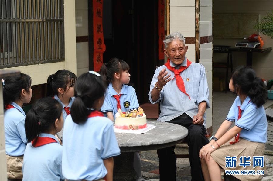 6月28日，吳興區(qū)第一小學(xué)學(xué)生聆聽八里店鎮(zhèn)前村村老黨員陳金茂（右二）講故事。 臨近“七一”，浙江省湖州市吳興區(qū)八里店鎮(zhèn)組織小學(xué)生開展“童心向黨”主題繪畫、聆聽老黨員講故事、參觀紅色教育基地等活動(dòng)。 新華社記者黃宗治攝