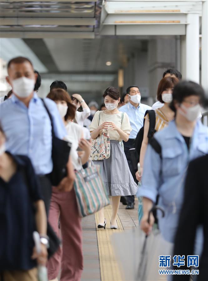 6月30日，在日本東京品川，人們下班后離開寫字樓走向車站。新華社記者 杜瀟逸 攝