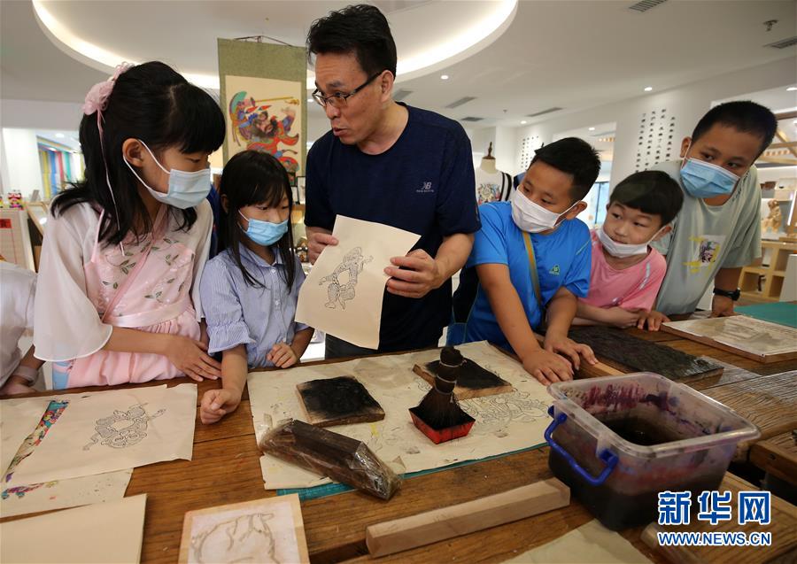 7月8日，山東省濰坊市濰城區(qū)城關街道十笏園社區(qū)的小朋友在了解木版年畫的印制。 當日，山東省濰坊市濰城區(qū)城關街道十笏園社區(qū)開展了“暑假學‘非遺’”活動，組織社區(qū)內(nèi)放暑假的孩子到十笏園文化街區(qū)現(xiàn)場體驗了解濰坊風箏、木版年畫、傳統(tǒng)花燈等非遺項目的制作工藝過程，感受家鄉(xiāng)傳統(tǒng)民間文化的魅力，樂享假期。 新華社發(fā)（張馳 攝）