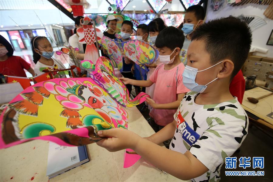 7月8日，山東省濰坊市濰城區(qū)城關街道十笏園社區(qū)的小朋友在了解濰坊風箏的制作工藝。 新華社發(fā)（張馳 攝）