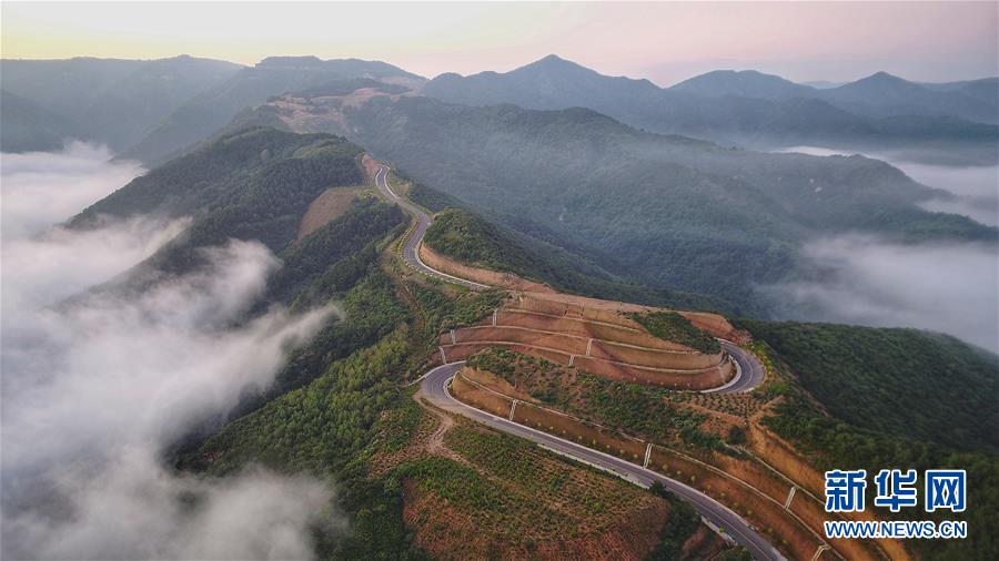 7月28日拍攝的鳳翅山至蟒頭山國(guó)家森林公園全域旅游示范路（無人機(jī)照片）。 位于陜西省延安市宜川縣鳳翅山至蟒頭山國(guó)家森林公園間的全域旅游示范路沿途風(fēng)景優(yōu)美，時(shí)?？梢姺v的云海。示范路方便旅客觀賞沿線叢林山水，也輻射帶動(dòng)了沿線3個(gè)貧困村的村民脫貧致富。 新華社發(fā)（趙潔 攝）
