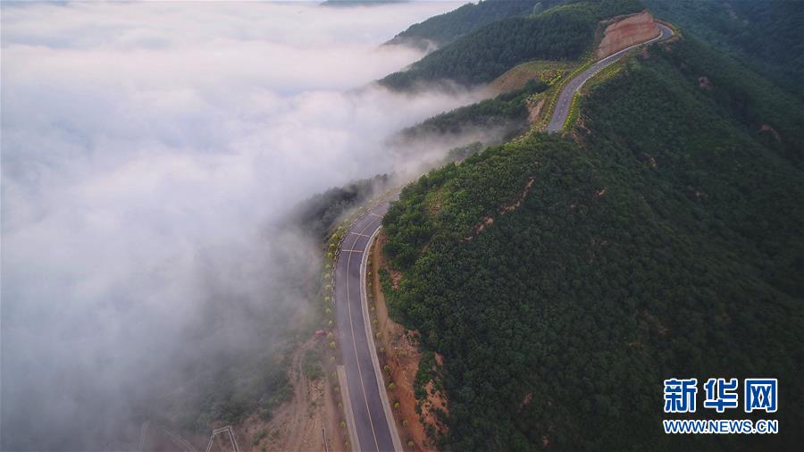 7月28日拍攝的鳳翅山至蟒頭山國(guó)家森林公園全域旅游示范路（無人機(jī)照片）。 位于陜西省延安市宜川縣鳳翅山至蟒頭山國(guó)家森林公園間的全域旅游示范路沿途風(fēng)景優(yōu)美，時(shí)?？梢姺v的云海。示范路方便旅客觀賞沿線叢林山水，也輻射帶動(dòng)了沿線3個(gè)貧困村的村民脫貧致富。 新華社發(fā)（趙潔 攝）
