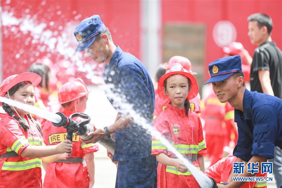 8月6日，消防員在畢節(jié)市消防救援支隊(duì)碧陽(yáng)大道特勤站帶領(lǐng)學(xué)生體驗(yàn)消防水槍。 新華社發(fā)（陳曦 攝）