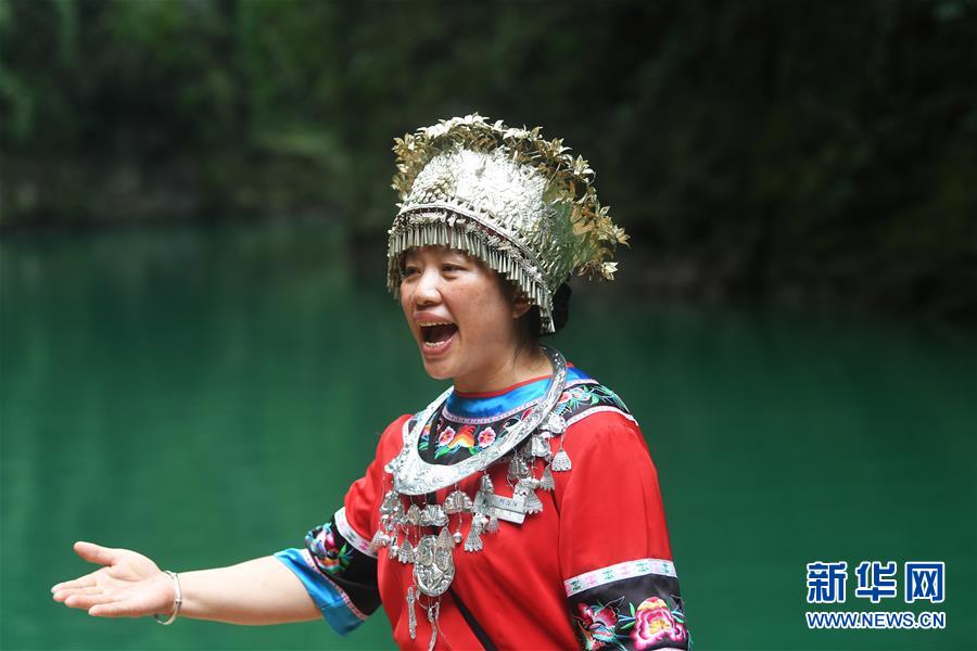 阿依河景區(qū)工作人員在為乘坐竹筏游覽的游客演唱山歌（8月13日攝）。 阿依河景區(qū)地處重慶市彭水苗族土家族自治縣，融山、水、林、泉、峽于一體，集雄、奇、險(xiǎn)、秀、幽于一身。近年來(lái)，阿依河景區(qū)利用良好的自然條件和豐富的民俗文化，不斷豐富旅游項(xiàng)目、改善旅游體驗(yàn)、拓展旅游業(yè)態(tài)，發(fā)展“美麗經(jīng)濟(jì)”。 新華社記者 王全超 攝