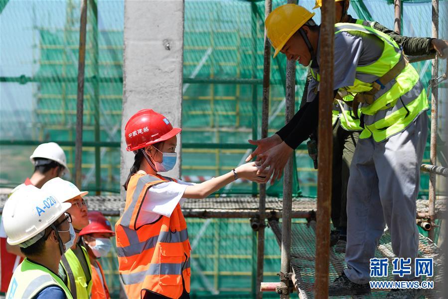 8月19日，“小候鳥”在浙江義烏世茂項目建設工地為工人送上清涼食品。 當日，在中建三局三公司華東分公司浙江義烏世茂項目建設工地，來自安徽、江西、湖北等地的26位外來務工人員子女參加了為他們組織的夏令營公益活動。即將陸續(xù)返鄉(xiāng)的“小候鳥”們上了一堂安全課程，還參觀了父母工作的建設工地。 新華社記者 黃宗治 攝