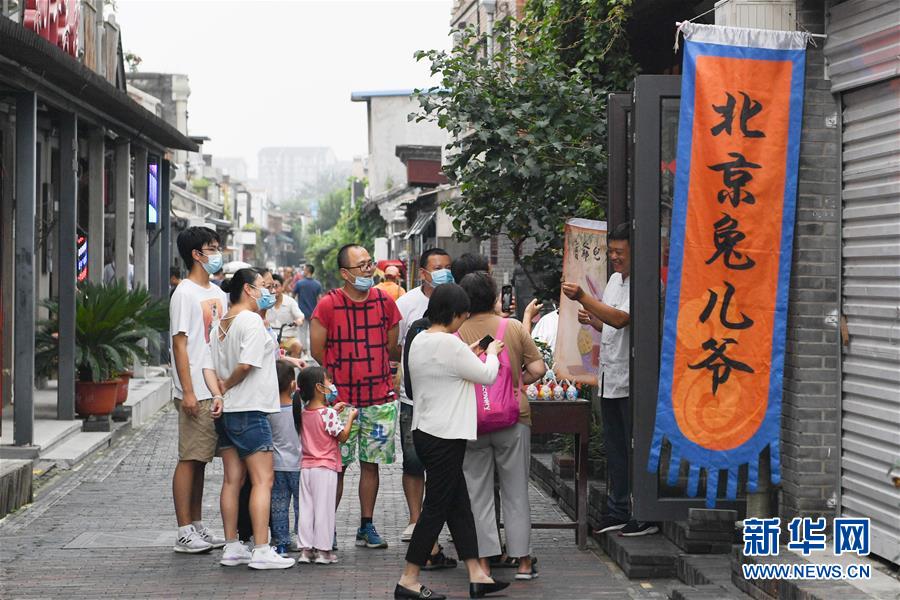 在北京楊梅竹斜街，游客在一家經(jīng)營(yíng)傳統(tǒng)老北京手工藝品“兔兒爺”的小店參觀（8月17日攝）。  新華社記者 鞠煥宗 攝