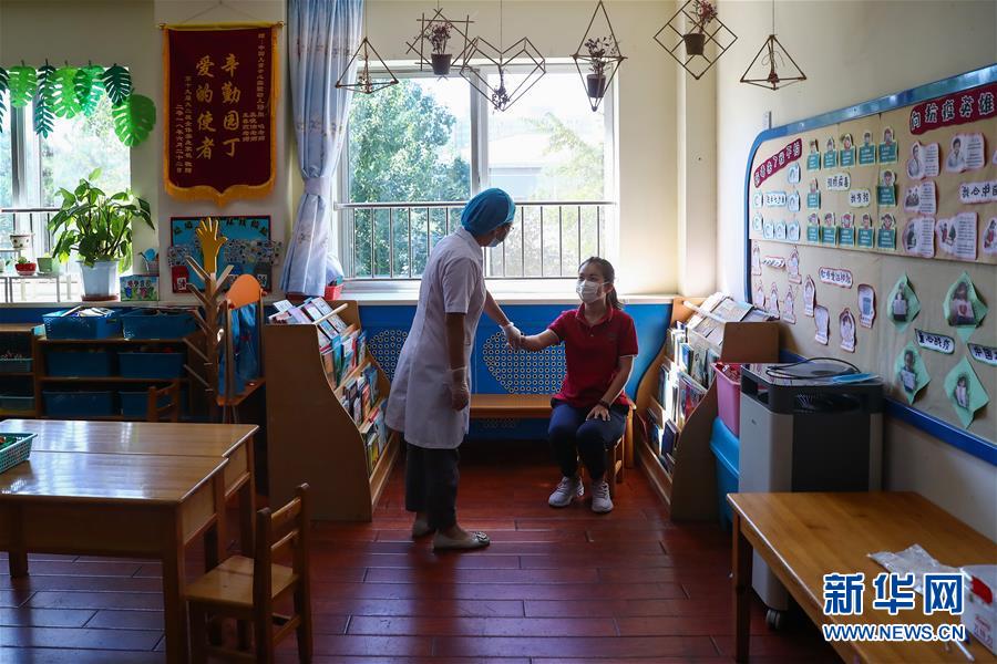 9月3日，在中國兒童中心實(shí)驗(yàn)幼兒園，參加模擬演練的校醫(yī)模擬為發(fā)燒的“學(xué)生”檢查。 近日，北京市各幼兒園為開園做準(zhǔn)備，部分幼兒園進(jìn)行開園的模擬演練。受新冠肺炎疫情影響，今年北京市中小學(xué)、幼兒園實(shí)行分批、錯峰開學(xué)。9月8日起，各類型幼兒園大班、中班開園。9月11日各類型幼兒園小班開園后，北京市中小學(xué)幼兒園將全部開學(xué)。 新華社記者 張玉薇 攝