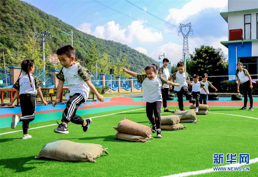 9月24日，孩子們?cè)诶蠋煹膸ьI(lǐng)下進(jìn)行跨越障礙物運(yùn)動(dòng)。 當(dāng)日，浙江省湖州市長(zhǎng)興縣煤山鎮(zhèn)槐坎中心幼兒園開(kāi)展校園金秋運(yùn)動(dòng)日活動(dòng)。孩子們?cè)诶蠋熀图议L(zhǎng)志愿者的帶領(lǐng)下，進(jìn)行走、跑、跳、平衡等戶(hù)外拓展運(yùn)動(dòng)技能的練習(xí)，讓孩子們?cè)诳鞓?lè)中鍛煉身體。 新華社記者 徐昱 攝