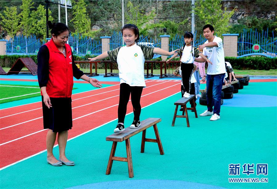 9月24日，孩子們?cè)诶蠋煹膸ьI(lǐng)下進(jìn)行走平衡木練習(xí)。 當(dāng)日，浙江省湖州市長(zhǎng)興縣煤山鎮(zhèn)槐坎中心幼兒園開(kāi)展校園金秋運(yùn)動(dòng)日活動(dòng)。孩子們?cè)诶蠋熀图议L(zhǎng)志愿者的帶領(lǐng)下，進(jìn)行走、跑、跳、平衡等戶(hù)外拓展運(yùn)動(dòng)技能的練習(xí)，讓孩子們?cè)诳鞓?lè)中鍛煉身體。 新華社記者 徐昱 攝