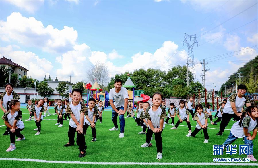 9月24日，孩子們?cè)诶蠋煹膸ьI(lǐng)下進(jìn)行身體拉伸運(yùn)動(dòng)。 當(dāng)日，浙江省湖州市長(zhǎng)興縣煤山鎮(zhèn)槐坎中心幼兒園開(kāi)展校園金秋運(yùn)動(dòng)日活動(dòng)。孩子們?cè)诶蠋熀图议L(zhǎng)志愿者的帶領(lǐng)下，進(jìn)行走、跑、跳、平衡等戶(hù)外拓展運(yùn)動(dòng)技能的練習(xí)，讓孩子們?cè)诳鞓?lè)中鍛煉身體。 新華社記者 徐昱 攝