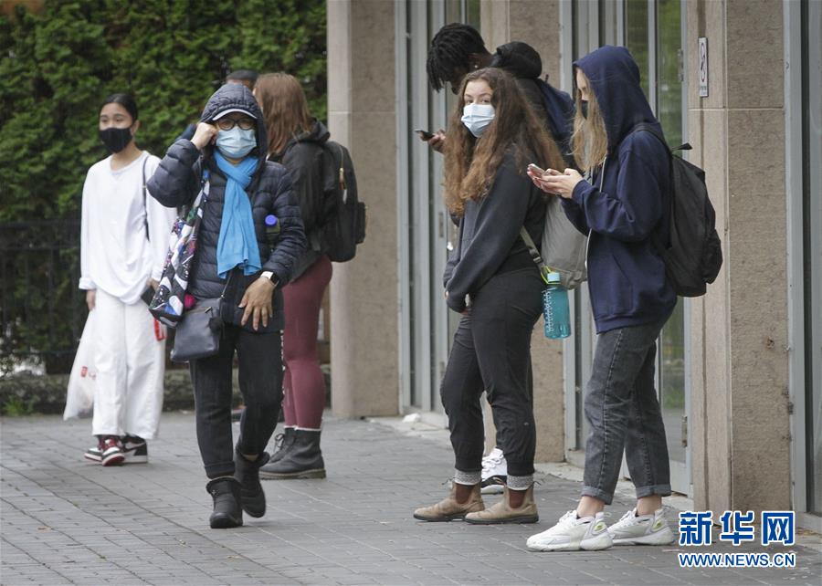 10月9日，在加拿大溫哥華，人們戴著口罩出行。 加拿大電視臺報道說，截至當(dāng)日下午，加拿大累計新冠確診病例上升至177613例，累計死亡病例9583例。 新華社發(fā)（梁森攝）