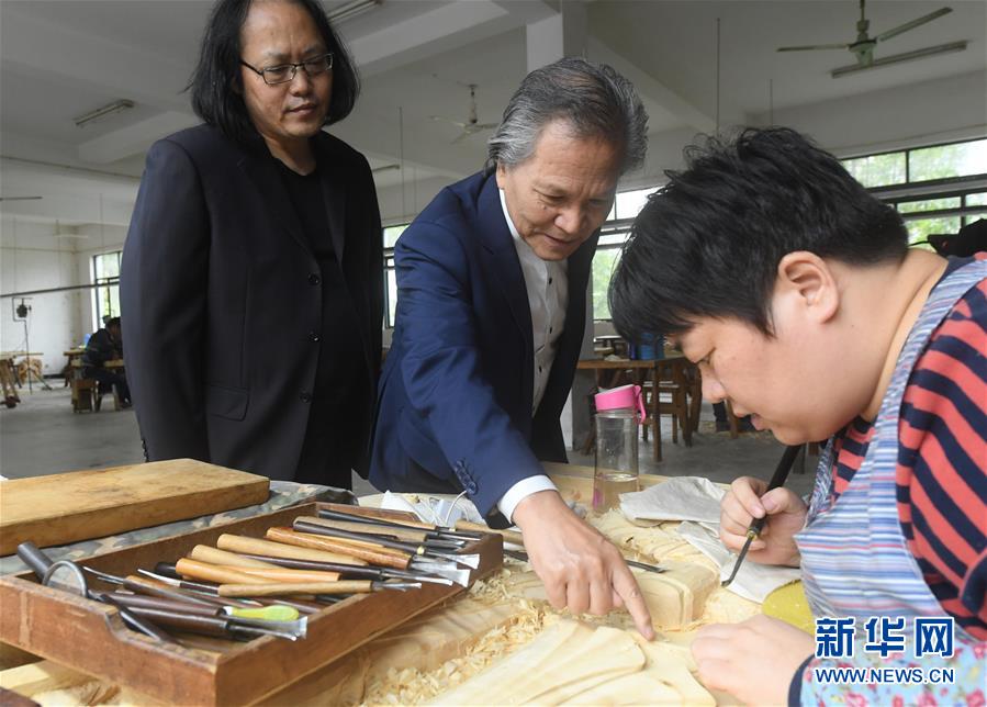 亞太地區(qū)手工藝大師、中國工藝美術(shù)大師陸光正（中）在其創(chuàng)作室內(nèi)和工作人員交流雕刻細(xì)節(jié)（10月19日攝）。新華社記者 翁忻旸 攝