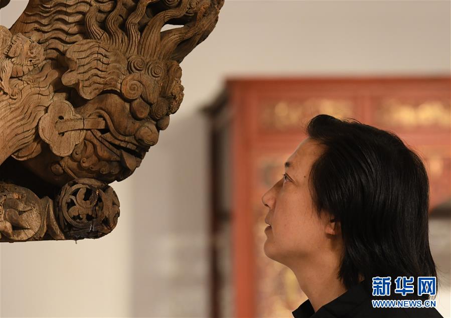 浙江省工藝美術(shù)大師陳國華在工作室觀察收藏的老木雕建筑構(gòu)件的細(xì)節(jié)（10月20日攝）。 新華社記者 翁忻旸 攝