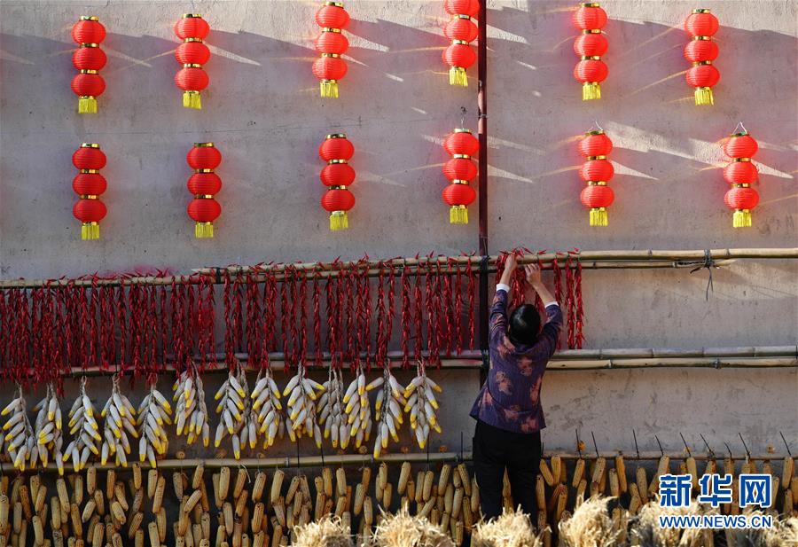 11月1日，一名村民在整理曬架上的農(nóng)作物。 深秋時節(jié)，位于福建省三明市尤溪縣洋中鎮(zhèn)的桂峰村，古民居與曬匾里五彩繽紛的農(nóng)作物，構(gòu)成五彩斑斕的調(diào)色板，展現(xiàn)秋收風(fēng)情。 新華社記者魏培全攝