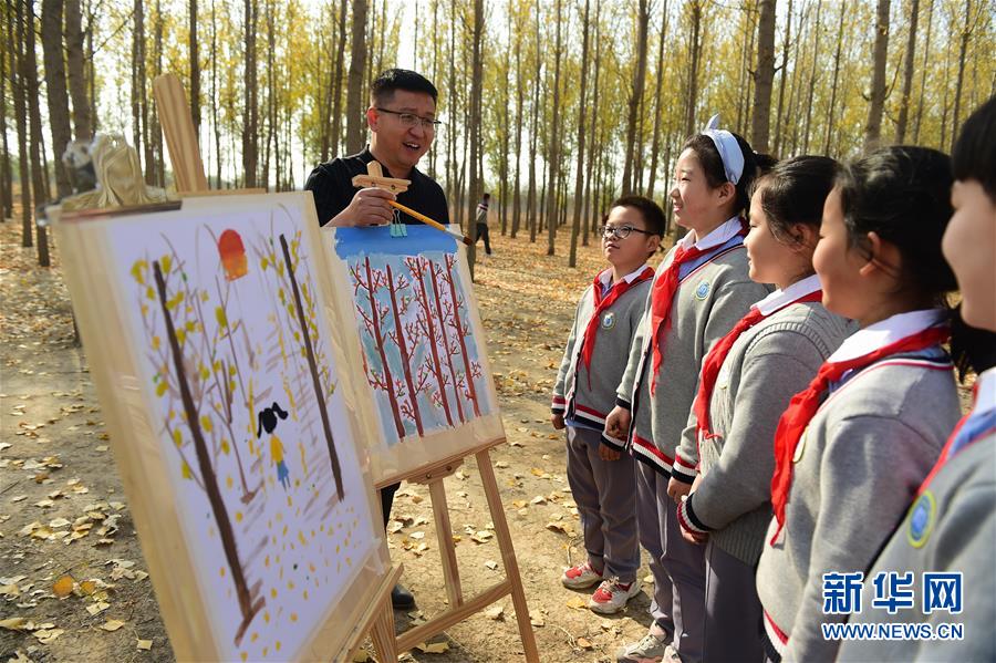 11月4日，滄州市實(shí)驗(yàn)小學(xué)的老師指導(dǎo)學(xué)生繪畫。 深秋時(shí)節(jié)，河北省滄州市實(shí)驗(yàn)小學(xué)美術(shù)興趣小組的學(xué)生在老師的帶領(lǐng)下走出教室，走進(jìn)大自然，以“多彩森林”為主題，用畫筆描繪斑斕秋色。 新華社發(fā)（傅新春 攝）