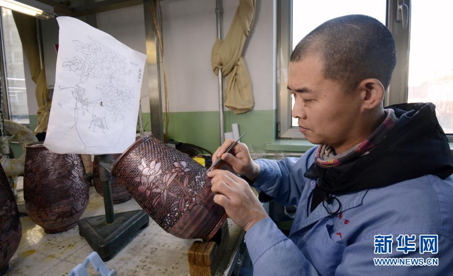 12月2日，北京琺瑯廠有限責(zé)任公司聾啞人掐絲技藝技師韓祺在制作景泰藍(lán)藝術(shù)品。從2005年起，北京琺瑯廠有限責(zé)任公司開始招收聾啞人技工，經(jīng)過老技師們的精心培養(yǎng)，目前有17位聾啞人成為景泰藍(lán)技師，有些還成為景泰藍(lán)技藝國家二級技師。通過學(xué)習(xí)景泰藍(lán)技藝，這些聾啞人在無聲的世界里有了一個(gè)多彩的人生。新華社記者 李欣 攝