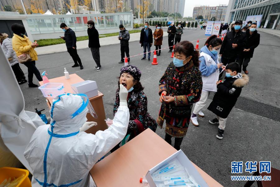 12月10日，在郫都區(qū)中醫(yī)醫(yī)院核酸檢測點，醫(yī)務人員對居民進行核酸取樣。自12月7日成都市郫都區(qū)新增新冠肺炎本土確診病例以來，郫都區(qū)中醫(yī)醫(yī)院進入24小時連軸轉狀態(tài)。該院信息科技術人員通宵達旦設計上線核酸檢測微信小程序，方便人們在手機上查看檢測報告。核酸檢測室的14名檢測員24小時3班倒，日均完成2000多份核酸檢測?！捌幢M全力與病毒爭分奪秒！”檢測科主任孔麗蕊說。新華社記者 沈伯韓 攝