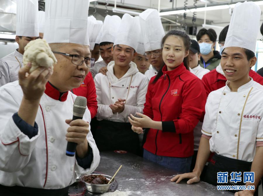 12月15日，順德廚師學(xué)院老師向參賽選手講解制作點(diǎn)心。新華社記者 黃國保 攝