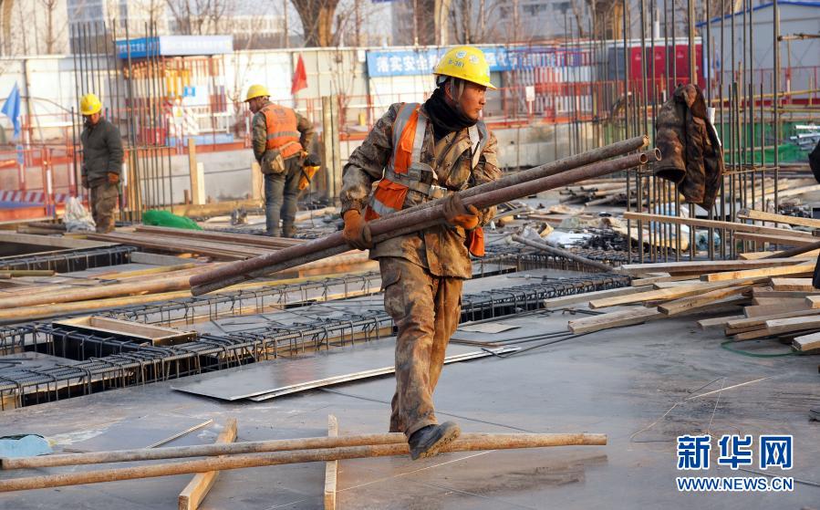 12月17日，在中建三局北京大興國際機(jī)場東航基地項(xiàng)目工地，工人在搬運(yùn)鋼管。近日，伴著寒潮到來，多地迎來寒冷天氣。在北京大興國際機(jī)場東航基地項(xiàng)目工地，勞動者們在凜冽寒風(fēng)中堅(jiān)守崗位。新華社記者 才揚(yáng) 攝