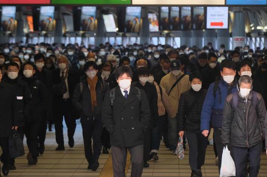 1月8日，在日本東京品川站，人們戴口罩出行。新華社 圖
