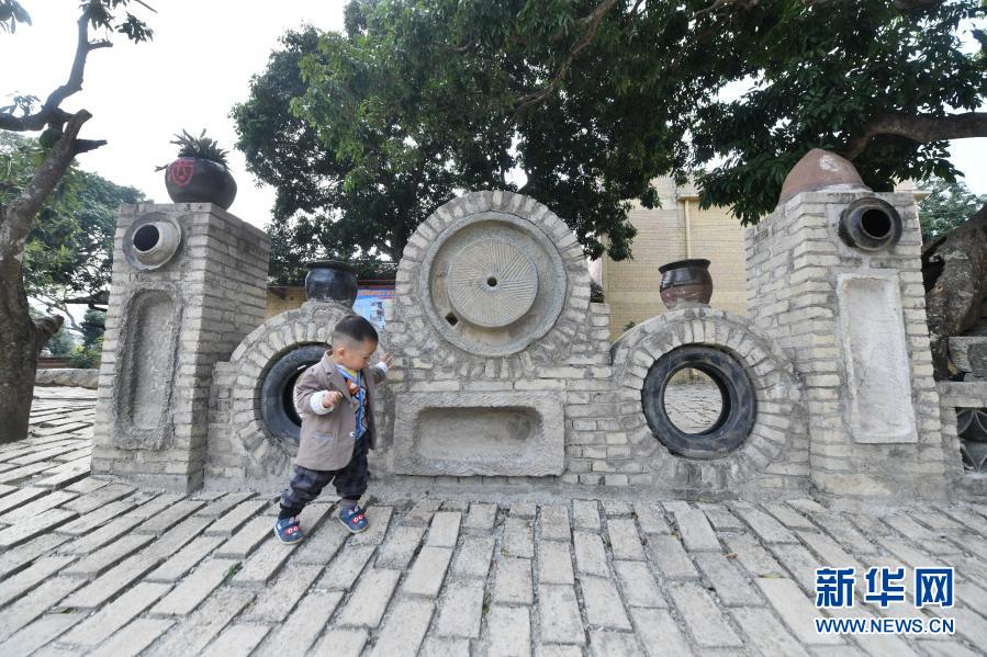 　　1月27日，在廣西欽州市浦北縣北通鎮(zhèn)清湖村劉屋自然村，小朋友在廢舊輪胎、石磨等打造的景觀前玩耍?！　〗陙?lái)，廣西欽州市浦北縣在建設(shè)美麗村屯工作中，遵循“低成本、全覆蓋、可持續(xù)”工作思路，巧用廢舊磚瓦農(nóng)具等物件打造成景觀，扮靚村屯，帶動(dòng)鄉(xiāng)村旅游業(yè)發(fā)展。　　新華社記者 黃孝邦 攝