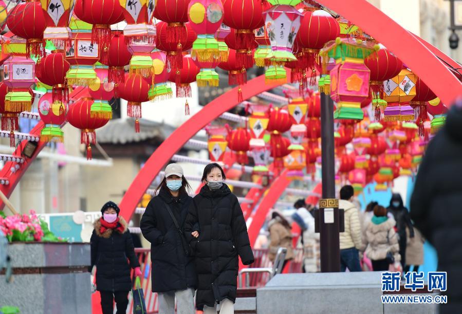 2月1日，在沈陽中街，市民從花燈下走過。春節(jié)臨近，年味漸濃，在遼寧沈陽中街步行街，福牛藝術(shù)雕塑和各色花燈吸引了眾多市民觀看拍照。新華社記者 楊青 攝