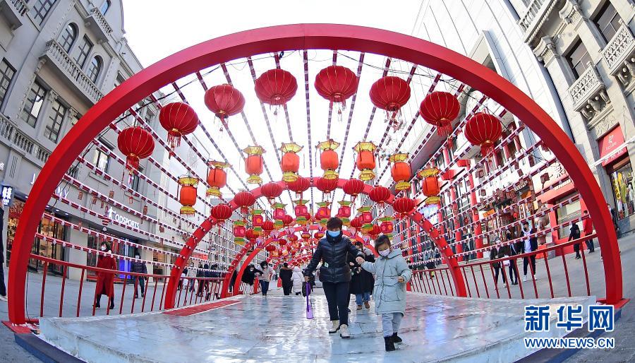 2月1日，在沈陽中街，市民從花燈下走過。春節(jié)臨近，年味漸濃，在遼寧沈陽中街步行街，福牛藝術(shù)雕塑和各色花燈吸引了眾多市民觀看拍照。新華社記者 楊青 攝