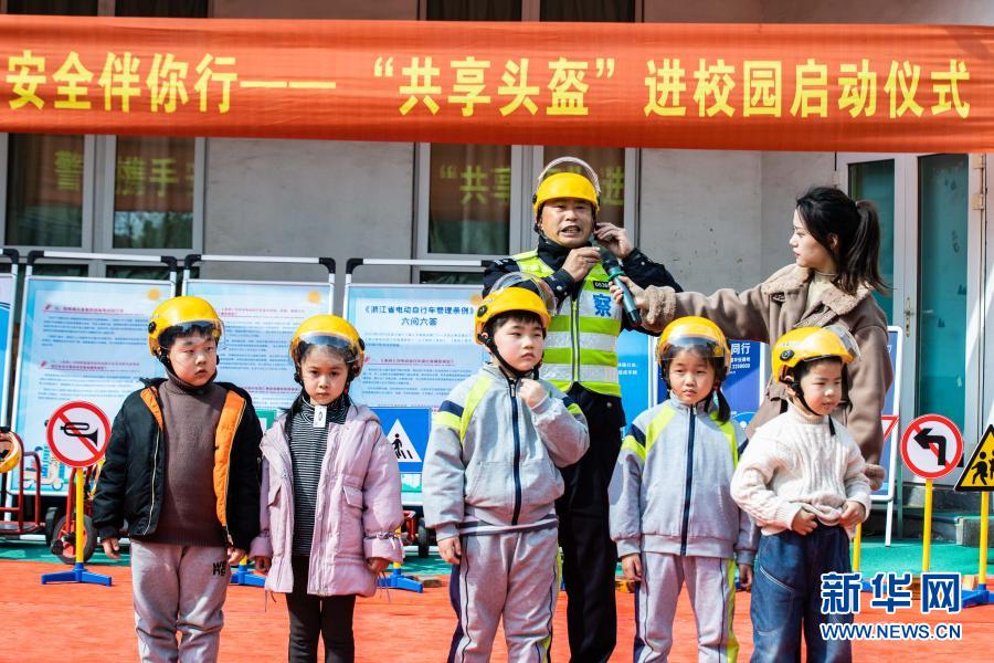 　　3月10日，交警現(xiàn)場(chǎng)演示如何正確佩戴頭盔?！　‘?dāng)日，在浙江省湖州市織里鎮(zhèn)晟舍幼兒園，織里鎮(zhèn)公安分局交巡警大隊(duì)啟動(dòng)“共享頭盔進(jìn)校園”活動(dòng)?？椑镦?zhèn)中小學(xué)校門口將陸續(xù)設(shè)立安全頭盔共享點(diǎn)，內(nèi)設(shè)大小頭盔，家長登記后可免費(fèi)取用頭盔，歸還后由學(xué)校負(fù)責(zé)清潔和消毒?；顒?dòng)旨在深入推進(jìn)全鎮(zhèn)電動(dòng)車專項(xiàng)整治行動(dòng)，普及交通安全法規(guī)，提高家長和學(xué)生們的交通安全意識(shí)。　　新華社記者 徐昱 攝