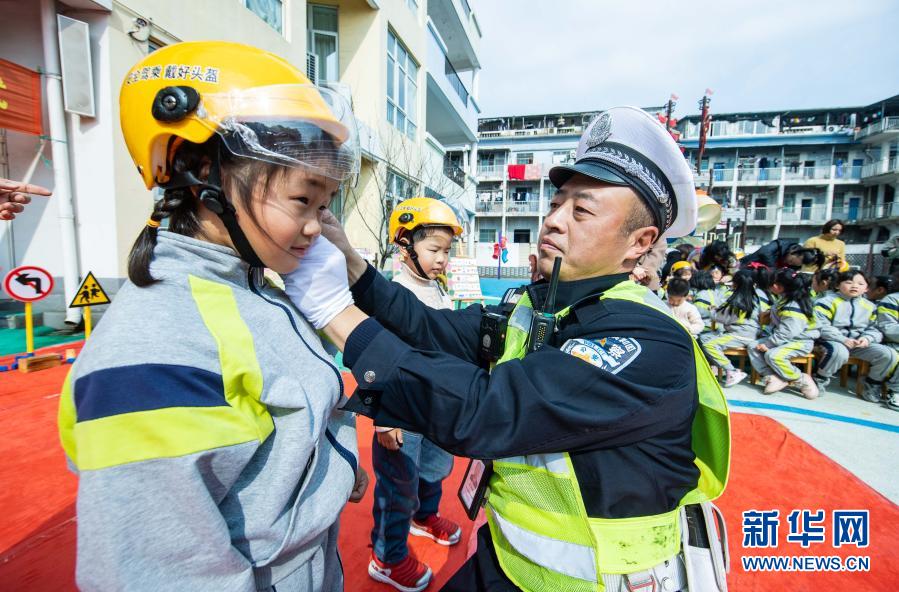 　　3月10日，交警現(xiàn)場(chǎng)指導(dǎo)小朋友如何正確佩戴頭盔?！　‘?dāng)日，在浙江省湖州市織里鎮(zhèn)晟舍幼兒園，織里鎮(zhèn)公安分局交巡警大隊(duì)啟動(dòng)“共享頭盔進(jìn)校園”活動(dòng)?？椑镦?zhèn)中小學(xué)校門口將陸續(xù)設(shè)立安全頭盔共享點(diǎn)，內(nèi)設(shè)大小頭盔，家長登記后可免費(fèi)取用頭盔，歸還后由學(xué)校負(fù)責(zé)清潔和消毒?；顒?dòng)旨在深入推進(jìn)全鎮(zhèn)電動(dòng)車專項(xiàng)整治行動(dòng)，普及交通安全法規(guī)，提高家長和學(xué)生們的交通安全意識(shí)。　　新華社記者 徐昱 攝