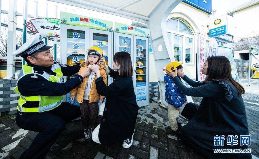 　　3月10日，交警現(xiàn)場(chǎng)指導(dǎo)家長和學(xué)生如何正確佩戴頭盔?！　‘?dāng)日，在浙江省湖州市織里鎮(zhèn)晟舍幼兒園，織里鎮(zhèn)公安分局交巡警大隊(duì)啟動(dòng)“共享頭盔進(jìn)校園”活動(dòng)?？椑镦?zhèn)中小學(xué)校門口將陸續(xù)設(shè)立安全頭盔共享點(diǎn)，內(nèi)設(shè)大小頭盔，家長登記后可免費(fèi)取用頭盔，歸還后由學(xué)校負(fù)責(zé)清潔和消毒。活動(dòng)旨在深入推進(jìn)全鎮(zhèn)電動(dòng)車專項(xiàng)整治行動(dòng)，普及交通安全法規(guī)，提高家長和學(xué)生們的交通安全意識(shí)?！　⌒氯A社記者 徐昱 攝