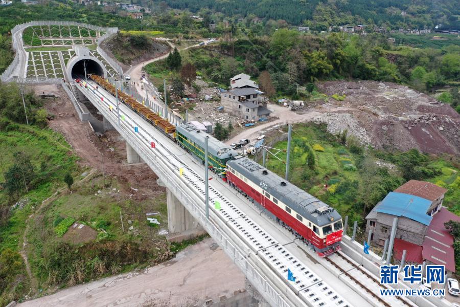 　　3月17日，在鄭萬高鐵重慶段施工現(xiàn)場，鋪軌牽引車進入作業(yè)現(xiàn)場（無人機照片）。新華社記者 唐奕 攝