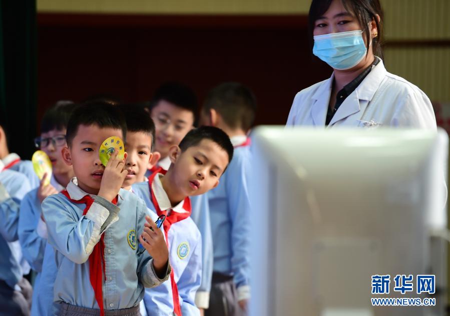 　　3月22日，在滄州市實驗小學，醫(yī)生志愿者指導學生進行裸眼視力檢查?！　‘斎眨颖笔嬷菔袑嶒炐W邀請滄州眼科醫(yī)院的“眼衛(wèi)士”醫(yī)生志愿服務隊走進校園，開展愛眼護眼公益講座，并為孩子們進行視力健康普查，建立“視力檔案”。今年3月是教育部部署的春季學期近視防控宣傳教育月。新華社發(fā)（傅新春 攝）