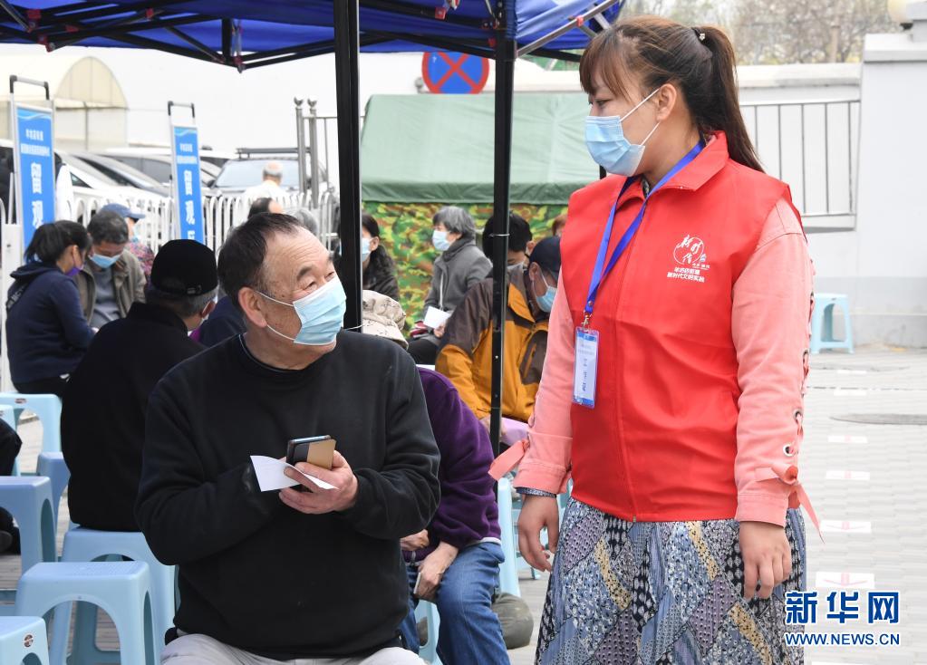 　　4月11日，在北京市海淀區(qū)羊坊店街道小馬廠社區(qū)新冠疫苗臨時接種點(diǎn)，街道工作人員（右）在留觀區(qū)與接種人員交流?！　〗眨本┦泻５韰^(qū)首輛移動疫苗接種車在羊坊店街道投入使用。據(jù)了解，該移動疫苗接種車內(nèi)劃分有1個登記臺和2個接種臺，車上配備醫(yī)用冷藏箱、空調(diào)等設(shè)備，保障新冠疫苗順利接種?！　⌒氯A社記者 任超 攝